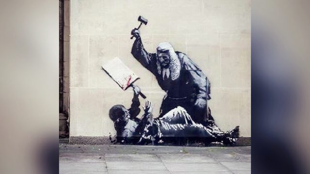 New Artwork by British Street Artist Banksy Appears on the Wall of Royal Courts of Justice, in London – Is Immediately Covered Up, as Police Weigh Charges of ‘Criminal Damage’