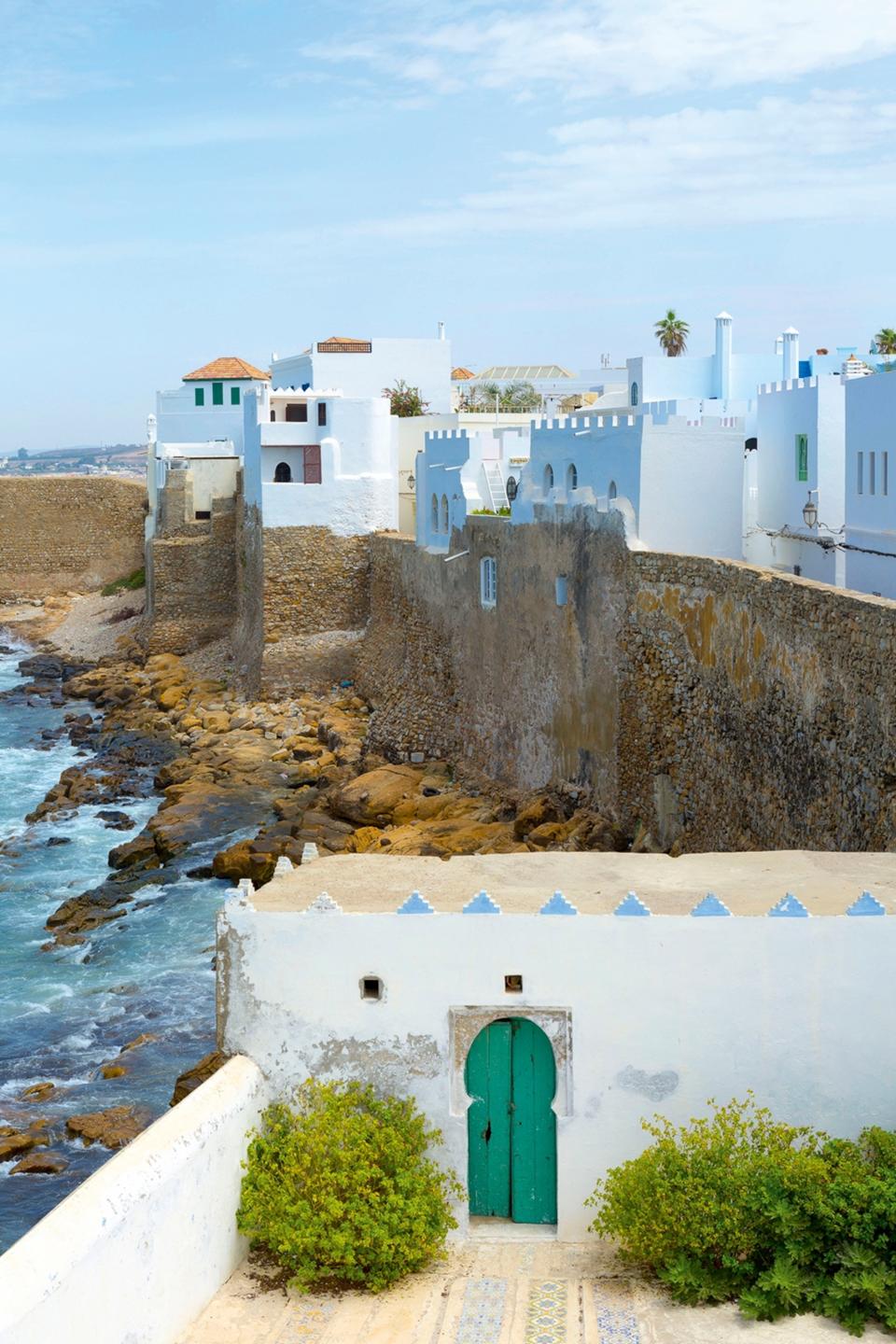 Whitewashed buildings perched above the sea and a rocky beach