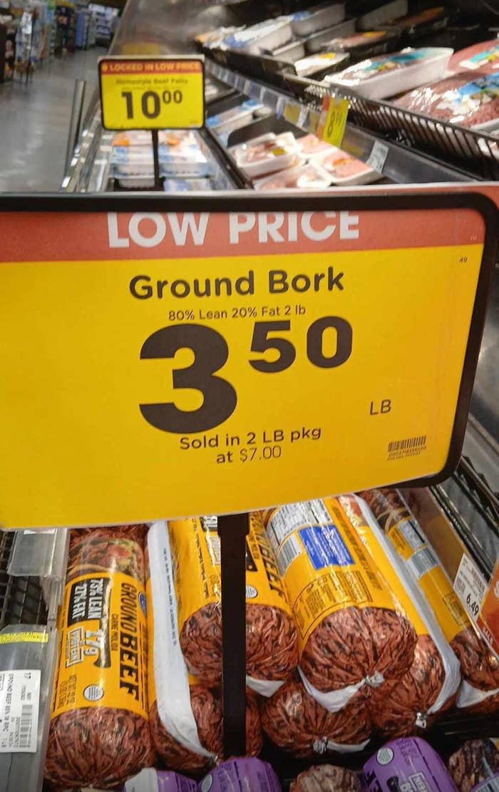 Sale sign for ground pork reading "Ground Bork 80% Lean 20% Fat 2 lb, $3.50 LB." Packages of ground beef visible underneath