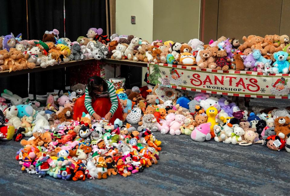 Jacie Kopstien, 10, of Palm Desert straightens up the stuffed toy area before it opens for kids to pick up gifts.