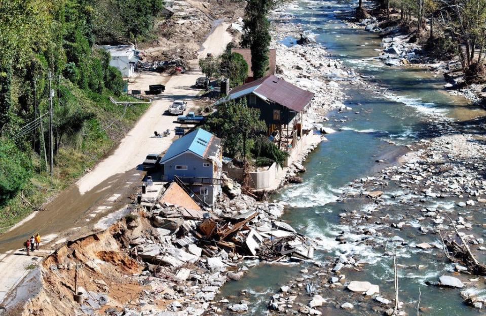 An aerial view of people standing near destroyed and damaged buildings in the aftermath of Hurricane Helene flooding on Oct. 8, 2024, in Bat Cave, North Carolina.  / Credit: Getty Images