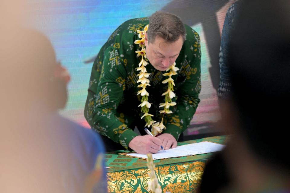 Elon Musk signs a deal for Starlink while wearing a traditional batik shirt