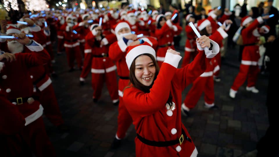 Workers dressed as Santa Claus parade around Tokyo's Marunouchi business district. - Issei Kato/Reuters/File