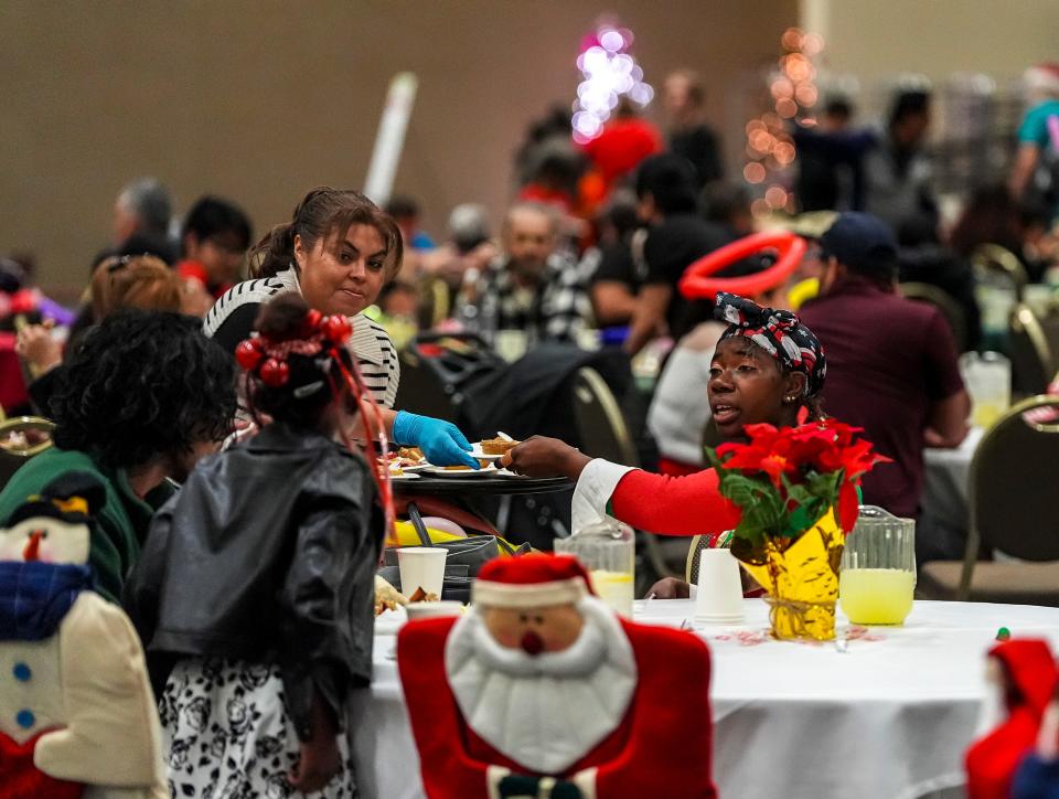 Akimmie McCaleb of Cathedral City takes a slice of pie from a volunteer server while enjoying her meal with her family.