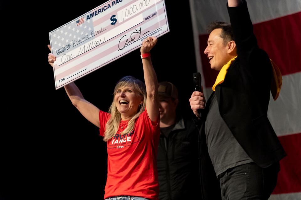 Elon Musk presents a $1 million check to a voter