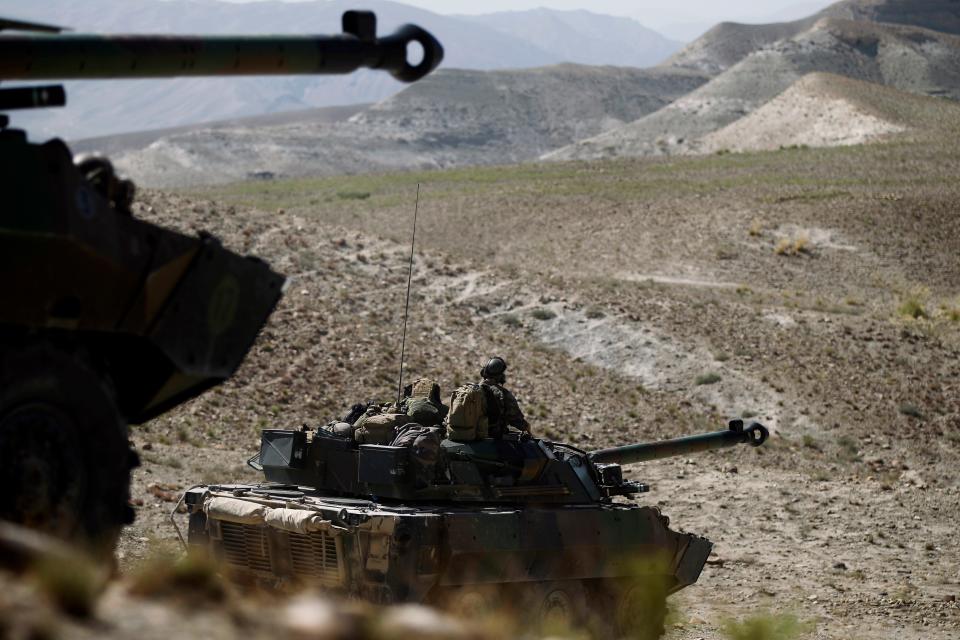 French soldiers sit atop an AMX 10RC tank.