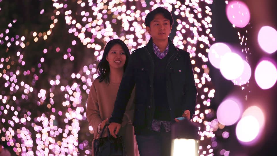 A couple walks through Christmas lights at a shopping area in Tokyo. - Koji Sasahara/AP/File