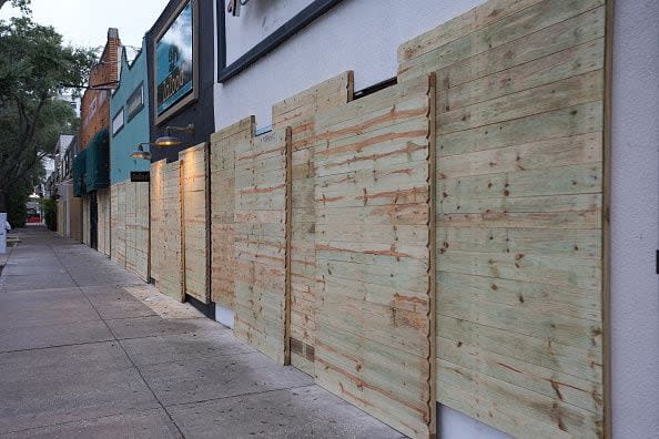 ST. PETERSBURG, FLORIDA, UNITED STATES - OCTOBER 8: Workers board up a business ahead of Hurricane Milton's expected landfall in St. Petersburg, Florida, US, on October 8, 2024. (Photo by Lokman Vural Elibol/Anadolu via Getty Images)