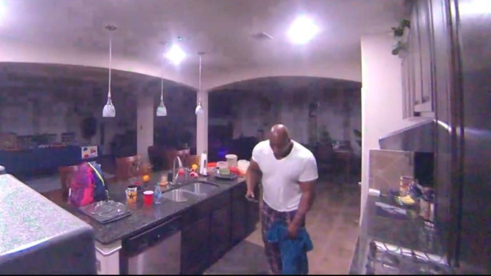 A still from home security video shows Renard Spivey holding a towel to his leg while on the phone with a 911 operator. / Credit: Evidence photo