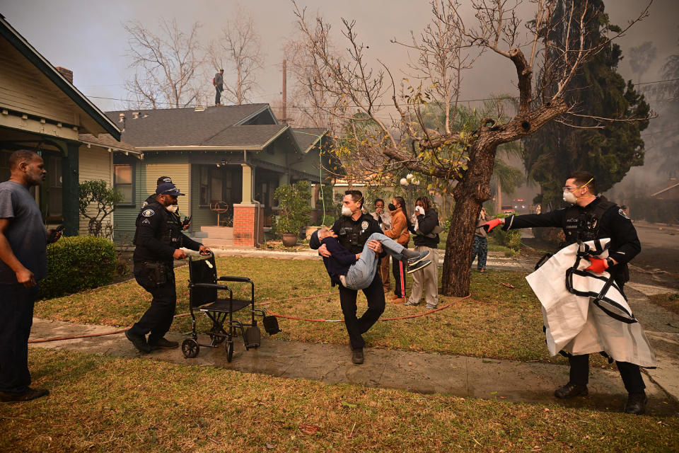 Rampaging wildfires around Los Angeles have killed at least two people, officials said January 8 as terrifying blazes leveled whole streets, torching cars and houses in minutes. (Robyn Beck / AFP via Getty Images)