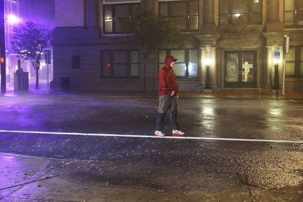 TAMPA, FLORIDA - OCTOBER 09: A television reporter stands in a downtown street as Hurricane Milton makes landfall on October 09, 2024, in Tampa, Florida. Milton, coming on the heels of the destructive Helene, hit as a category 3 storm with winds of over 100 mph, though avoiding the projected direct hit on Tampa. Instead, the storm, which earlier had reportedly spawned tornadoes, landed about 70 miles south of Tampa near Siesta Key, a strip of white-sand beaches that's home to 5,500 people, according to published reports.  (Photo by Spencer Platt/Getty Images)