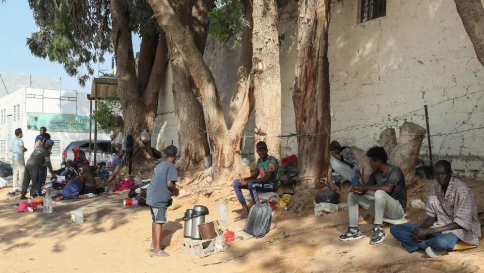 Refugees from Sudan sit down in front of the UNHCR offices in Tripoli, Libya, on 15 July 2023. No-one pictured is in the article.