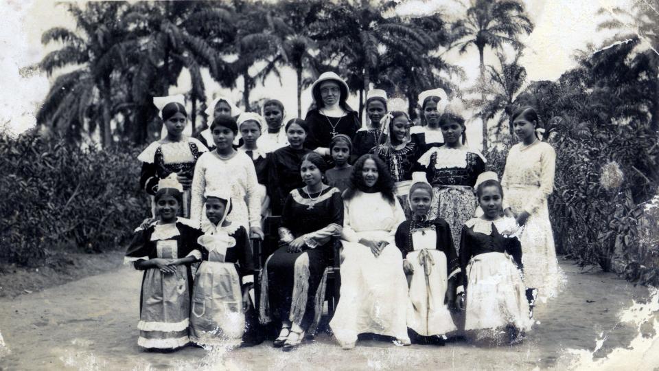 A black-and-white picture of a group of girls and a nun at the Order of Saint Joseph Cluny convent posing for a picture.