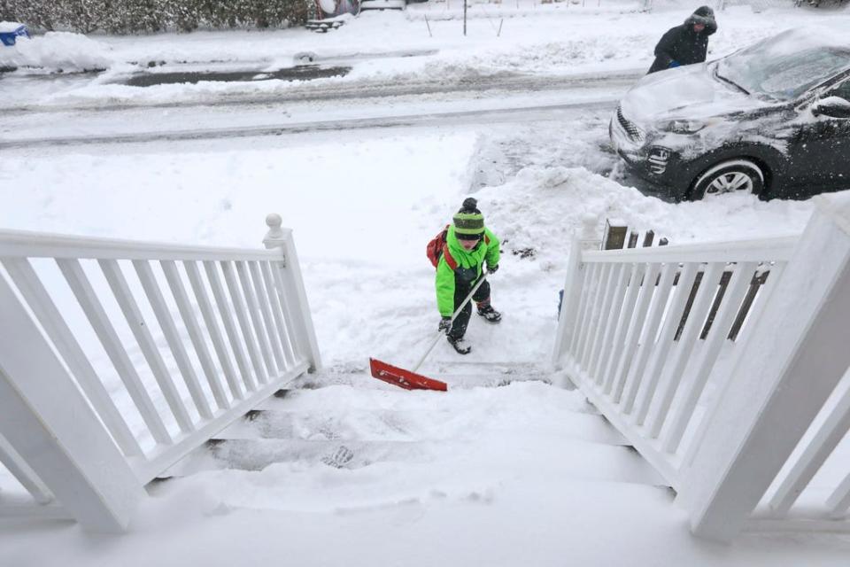 With backpack ready for school, Gavyn K. 6, helps his mom Sahwna M. shovel the snow in front of their home in New Bedford after a snowfall that covered the region.  [ PETER PEREIRA/THE STANDARD-TIMES/SCMG ]