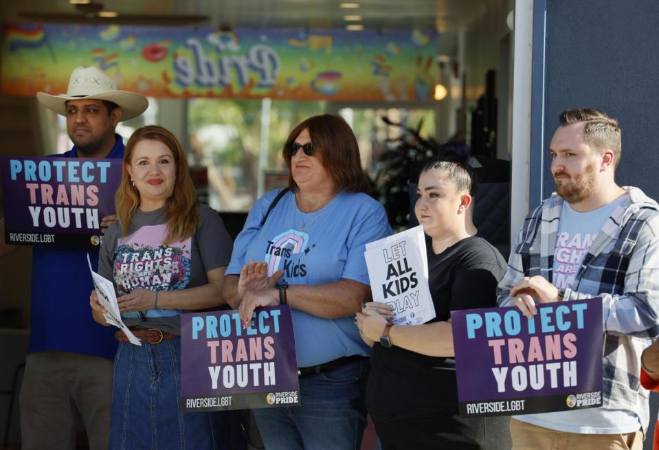 A coalition of LGBTQ+ supporters listens to speakers during a press briefing