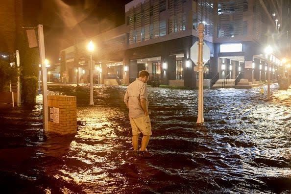 FORT MYERS BEACH, FLORIDA - OCTOBER 09: Brandon Marlow walks through surge waters flooding the street after Hurricane Milton came ashore in the Sarasota area on October 09, 2024, in Fort Myers, Florida. People are waiting to assess the damage after the Cat 3 hurricane came ashore. (Photo by Joe Raedle/Getty Images)