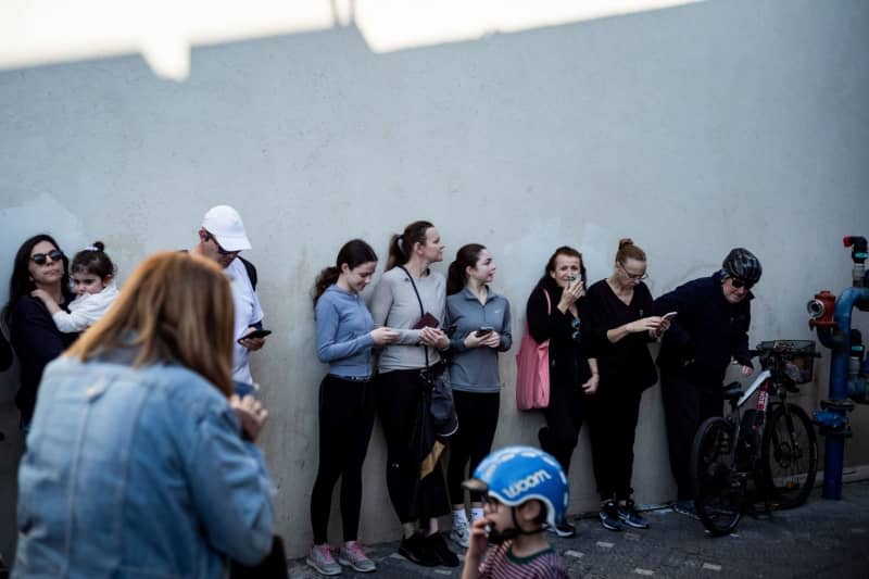 People take shelter after sirens sounded in Tel Aviv, following a ballistic missile attack from Yemen. According to the IDF, the Israeli air force intercepted missiles launched by Yemen's Houthis on Saturday morning. Ilia Yefimovich/dpa