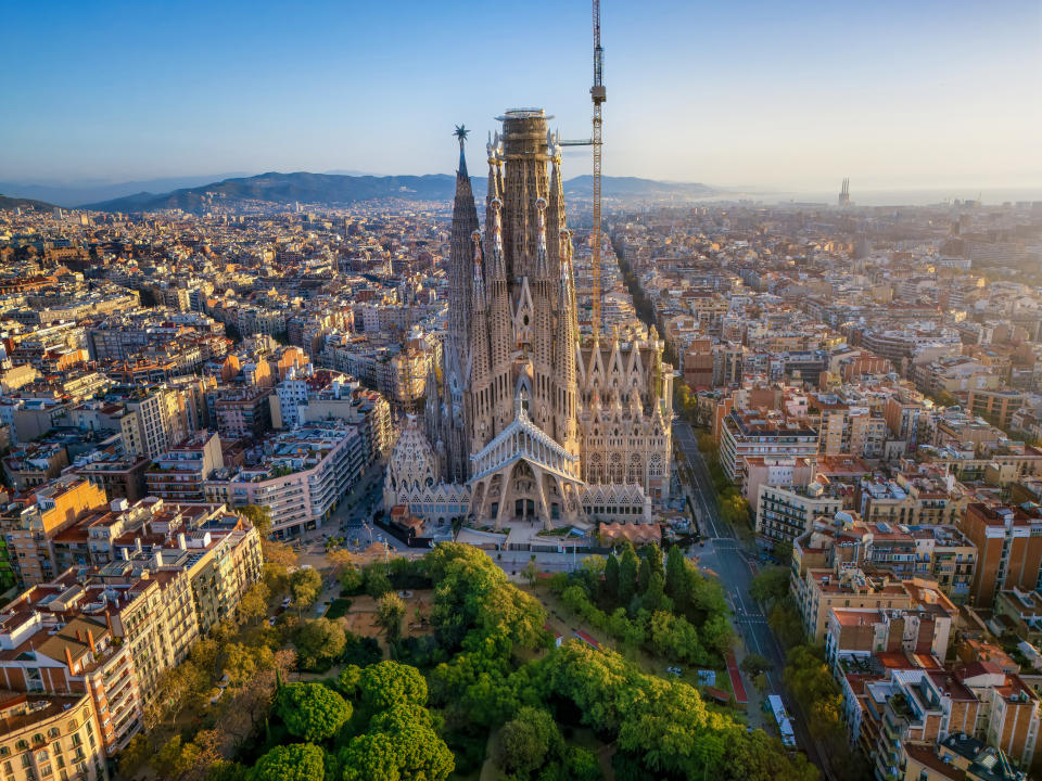 Panoramic aerial view of the famous Sagrada Familia church, in golden sunrise light. Barcelona, Spain