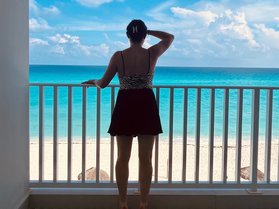 simone looking out at the ocean from a hotel balcony