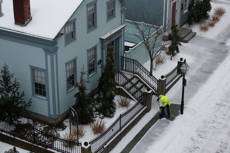 A man shovels the snow on the sidewalk on N Second Street in New Bedford