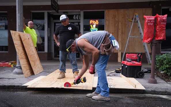 ST. PETERSBURG, FLORIDA, UNITED STATES - OCTOBER 8: Workers board up a business ahead of Hurricane Milton's expected landfall in St. Petersburg, Florida, US, on October 8, 2024. (Photo by Lokman Vural Elibol/Anadolu via Getty Images)