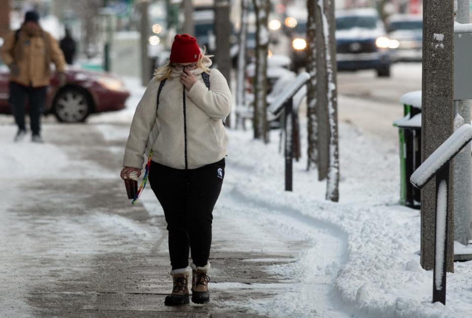 A woman braves the frigid temperatures, Tuesday, Jan. 21, 2025, as she walks down East Grand River Avenue in East Lansing.