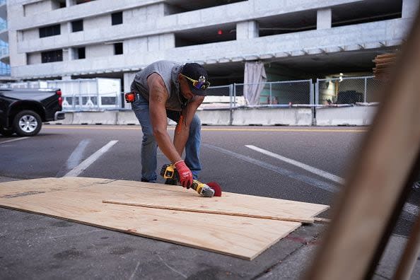 ST. PETERSBURG, FLORIDA, UNITED STATES - OCTOBER 8: Workers board up a business ahead of Hurricane Milton's expected landfall in St. Petersburg, Florida, US, on October 8, 2024. (Photo by Lokman Vural Elibol/Anadolu via Getty Images)