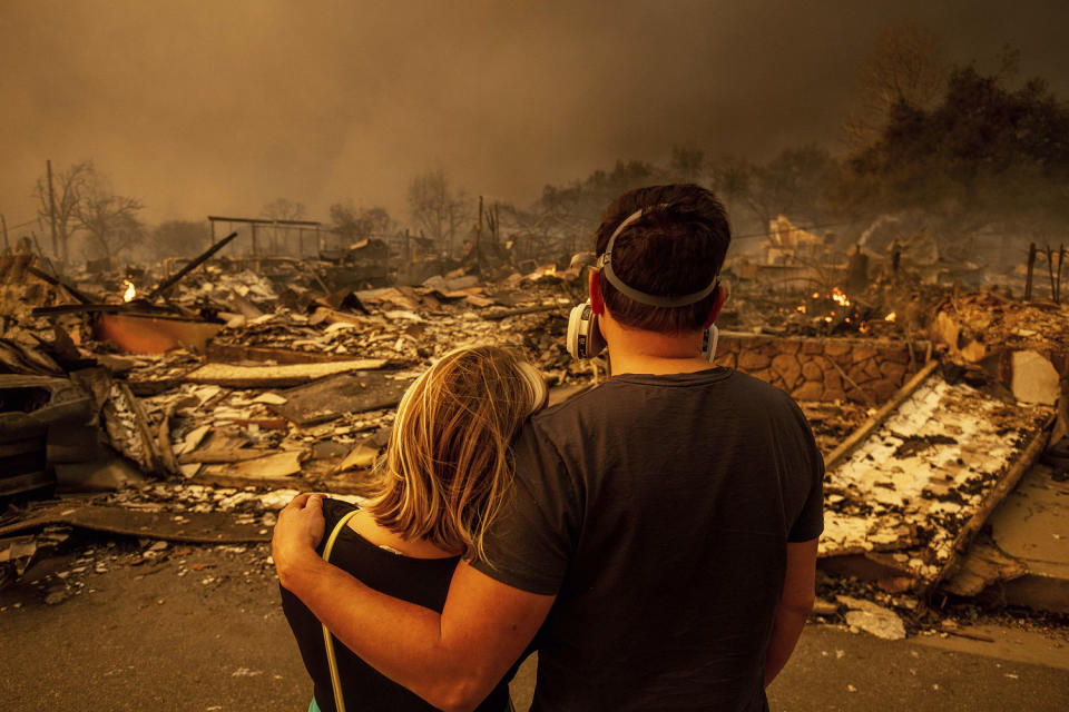 Megan Mantia, left, and her boyfriend Thomas, only first game given, return to Mantia's fire-damaged home after the Eaton Fire swept through the area in Altadena, Calif., on Jan. 8, 2025. (Ethan Swope / AP)