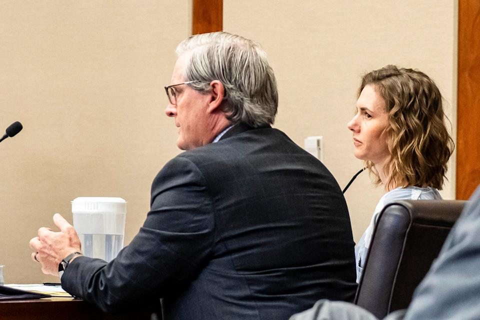 Franke sits in a courtroom, clad in a prison jumpsuit next to her lawyer, an older white man in a dark grey suit. (Sheldon Demke / St. George News via AP, Pool)