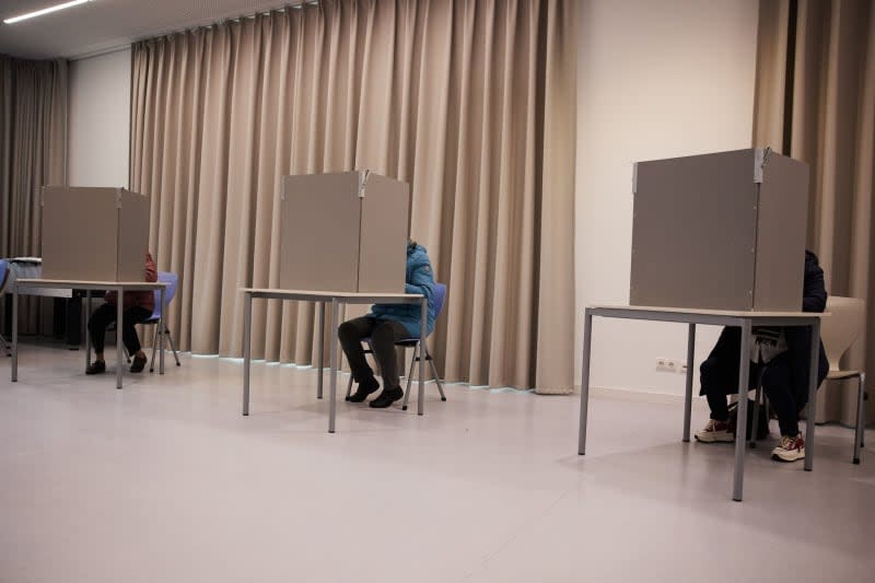 Citizens cast their votes at a polling station in a school in Pankow in the Bundestag election. Polls have opened across Germany, with millions of voters set to cast their ballots in one of the most pivotal parliamentary elections in recent memory. Joerg Carstensen/dpa