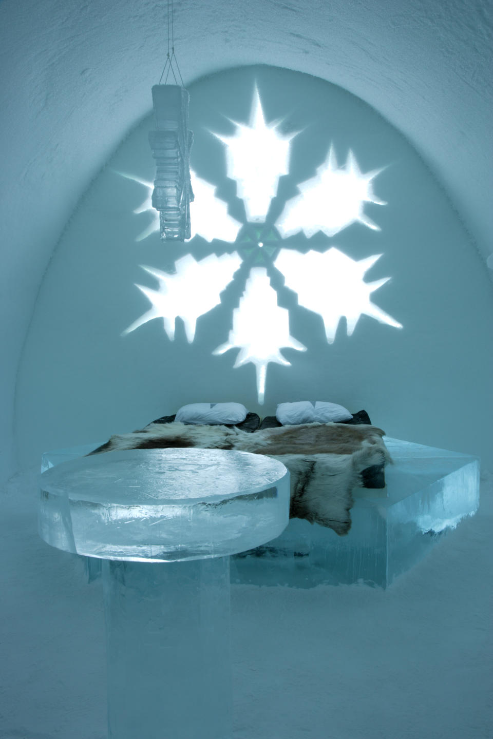 'Art suite' with snowflake theme in the Swedish Ice Hotel. Table and bed are created from ice blocks cut from the River Torne. Mattress on the bed is covered with reindeer skins.