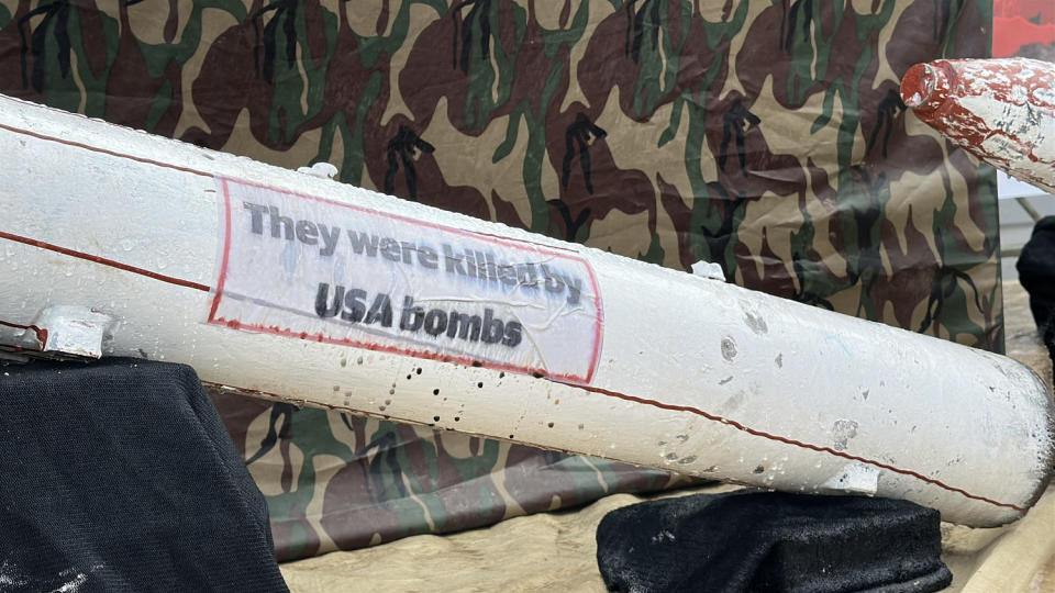 A white missile with text that reads "They were killed by USA bombs" (NBC News)