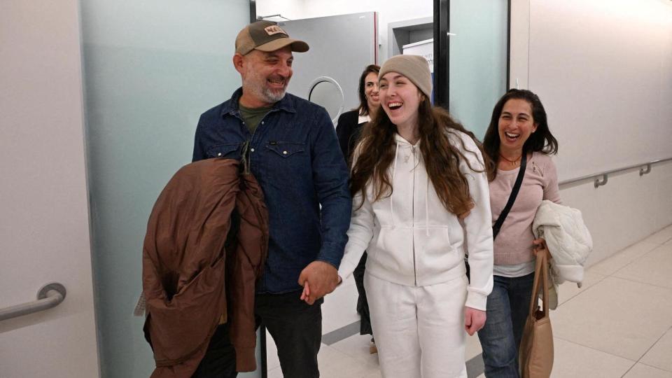 Ab beaming Naama Levy holds hands with her father and mother by her side as they leave a facility in Israel in a picture released by Israeli authorities on 25 January 2025.