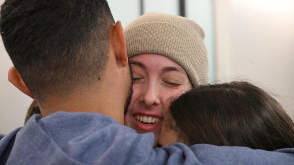 A zoomed-in crop of Naama Levy smiling as she's hugged by her parents during their reunion in Israel on 30 January