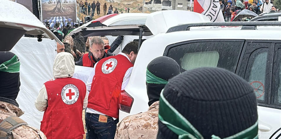 Red Cross workers load the caskets into a car (NBC News)