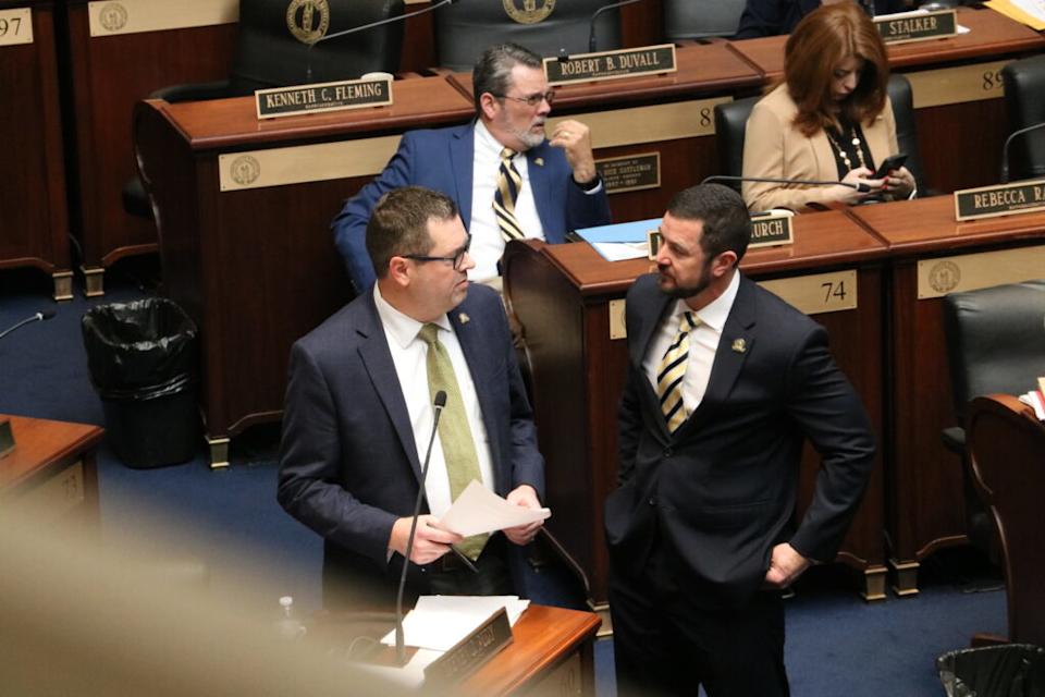 Rudy and Meade stand by each other in the aisle.