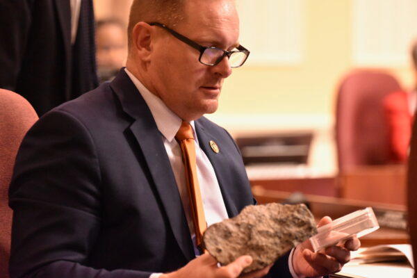  Sen. Jason C. Gallion (R-Cecil and Harford) examines samples of chromite during a hearing on a bill to add the mineral to the list of state symbols. (Photo by Bryan P. Sears/Maryland Matters)