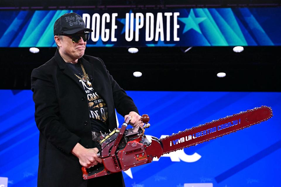 Elon Musk holds a chainsaw during an appearance at the 2025 Conservative Political Action Conference.