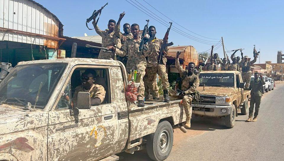 Two army trucks carrying cheering soldiers belonging to the Sudanese military on a street in northern Khartoum - March 2025