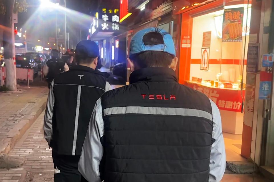 Tesla workers on a street near the Shanghai Gigafactory last month. (CNBC)