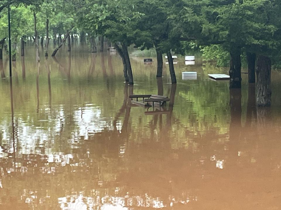 Benches and tables in Lucy Park were submerged Thursday morning as the Wichita River rose from its banks.
