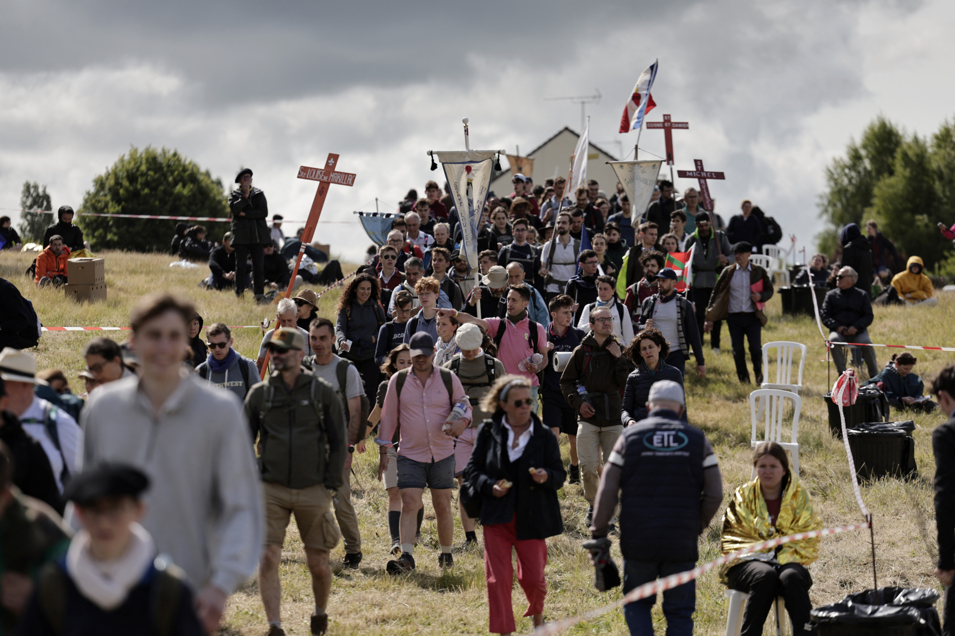 Pilgrims hold crosses, banners and flags as they arrive for the Mass, during the traditional Pentecostal pilgrimage from Paris to Chartres, in Sonchamp, near Paris, on June 8, 2025. From the church of Saint-Sulpice in Paris, thousands of people began their march towards Chartres on June 7, 2025 for the great traditionalist pilgrimage, which is attracting a record 19,000 Catholics this year, despite certain tensions with the episcopate. (Photo by STEPHANE DE SAKUTIN / AFP) (Photo by STEPHANE DE SAKUTIN/AFP via Getty Images)