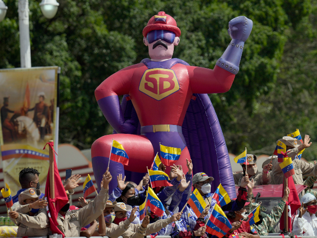 A float with local militia and a blow up doll of the character Super Bigote, in the likeness Venezuelan President Nicolas Maduro, participates in the parade marking Independence Day in Caracas, Venezuela, Tuesday, July 5, 2022. Venezuela is marking 211 years of its declaration of independence from Spain. (AP Photo/Ariana Cubillos)