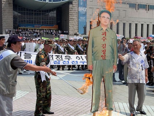 Veteran South Korean soldiers set alight an effigy (C) of North Korean leader Kim Jong-Il, 04 July 2002, during a demonstration in front of the Seoul War Museum. Some 3,000 veterans gathered to protest against North Korea and South Korean President Kim Dae-Jung's "Sunshine Policy" of reconciliation towards the North, following the death of four South Korean soldiers in a clash at sea last week. AFP PHOTO/CHOI JAE-KU (Photo by CHOI JAE-KU / AFP)