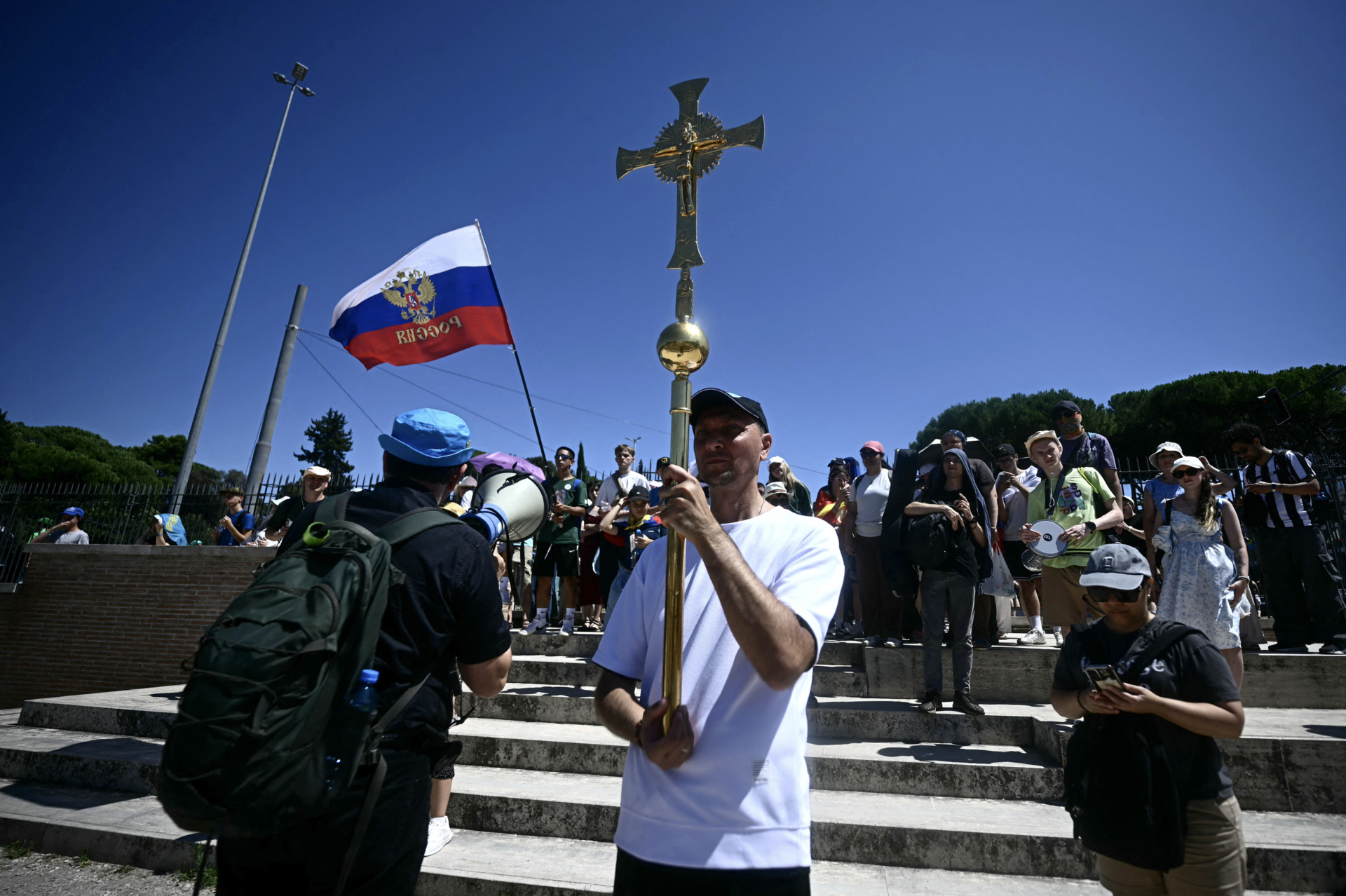 A Russian faithful holding a crucifix arrives to attend in a mass confession event to receive the sacrament of reconciliation, held under tents at the Circo Maximus as part of the Youth Jubilee in Rome, on August 1, 2025. About 1 million people are expected to attend the final Mass on August 3, 2025, with Pope Leo XIV in Rome's Tor Vergata neighbourhood, just over two months after he became the head of the Catholic Church and the first American Pope. (Photo by Filippo MONTEFORTE / AFP) (Photo by FILIPPO MONTEFORTE/AFP via Getty Images)