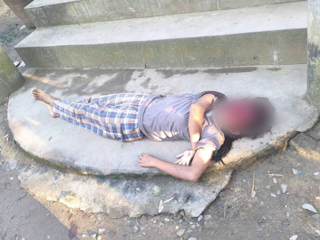 Person lying on concrete steps in casual clothing, surrounded by dirt and small stones, indicating a possibly distressing situation.