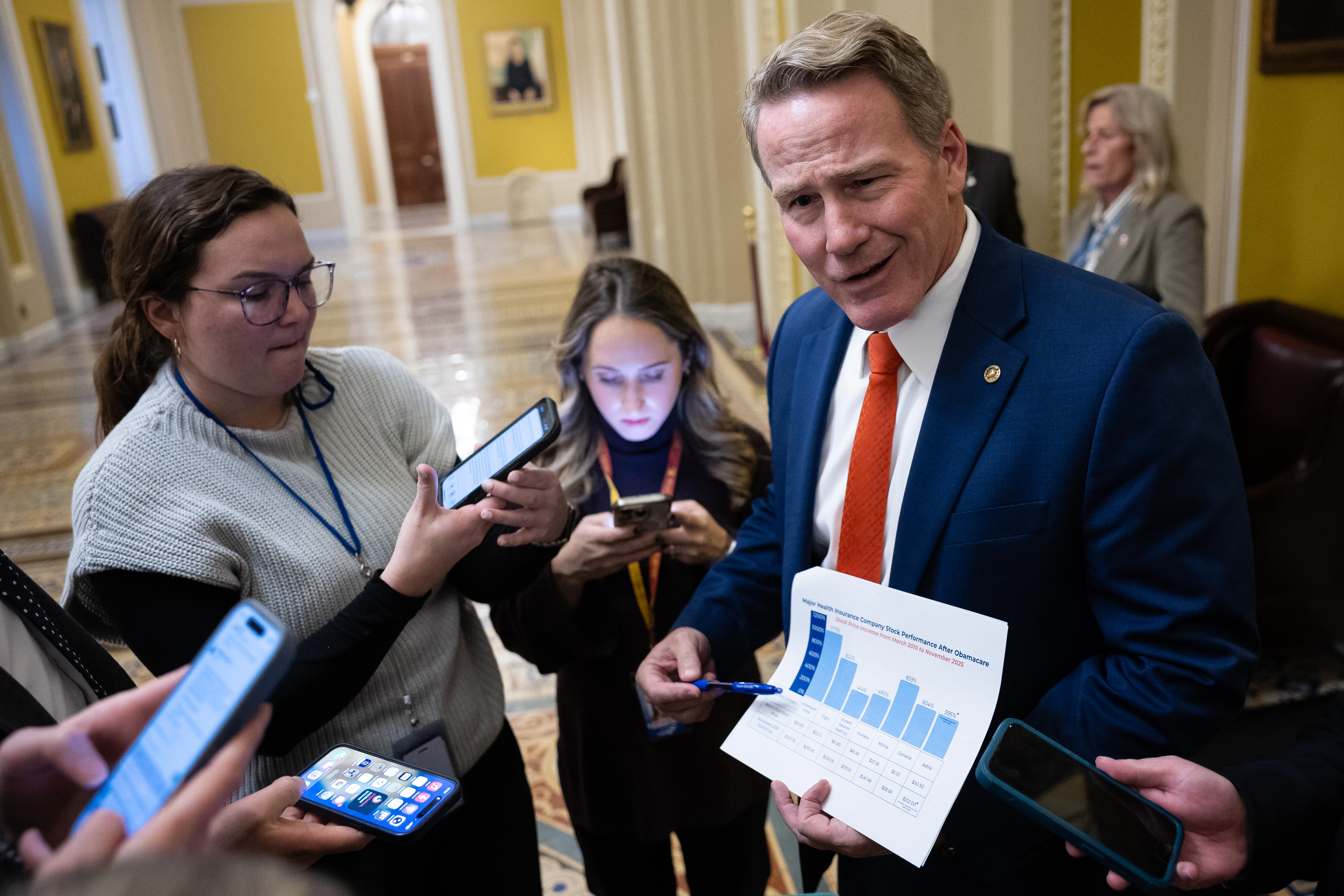 Sen. Jon Husted (R-Ohio) displays data about major health insurance company stock performance after Obamacare as he speaks with reporters at the U.S. Capitol on the 38th day of a government shutdown, Nov. 7, 2025.