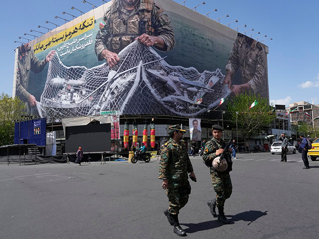 Title: Iran War Image ID: 26095383025698 Article: Two police officers walk in front of an anti-U.S. billboard depicting the American aircrafts into the Iranian armed forces fishing net with signs that read in Farsi: "The Strait of Hormuz will remain closed, The entire Persian Gulf is our hunting ground," at the Eqelab-e-Eslami, or Islamic Revolution square in downtown Tehran, Iran, Sunday, April 5, 2026. (AP Photo/Vahid Salemi)