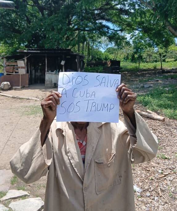 Cuba holds up sign reading "God save Cuba, SOS Trump" in Villa Clara, Cuba, May 20, 2026.