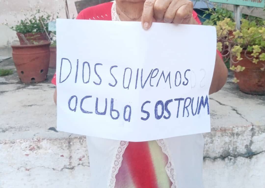 Woman holds up sign reading "God save Cuba, SOS Trump" in Santi Spiritus, Cuba, May 20, 2026.